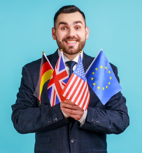 Homme en costume portant des drapeaux - Découvrez de nouvelles cultures et d'autres modes de vie pendant vos études à l'étranger !