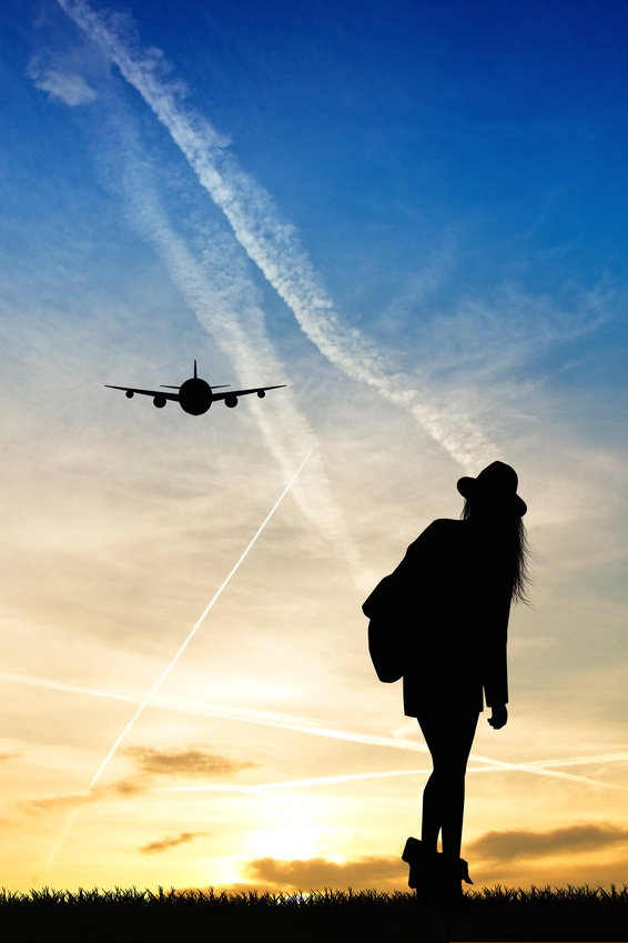 Silhouette d'une femme regardant un avion dans les airs - la SMENO vous conseille son assurance santé à l'étranger pour votre séjour