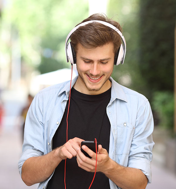 Marchez quand vous le pouvez en milieu urbain Jeune écoutant de la musique à pied