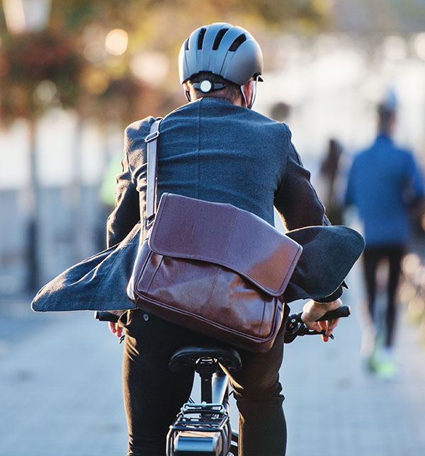 La SMENO recommande l'utilisation d'un vélo pour vous déplacer jeune homme à vélo dans la rue - Le vélo est un excellent moyen de déplacement en ville
