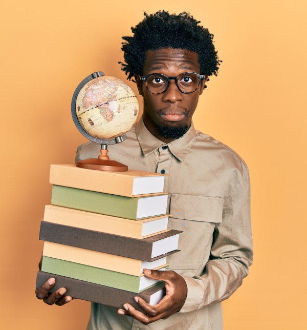 Etudiant portant une pile de livres - La SMENO vous accompagne dans vos études et vous conseille de prendre une mutuelle
