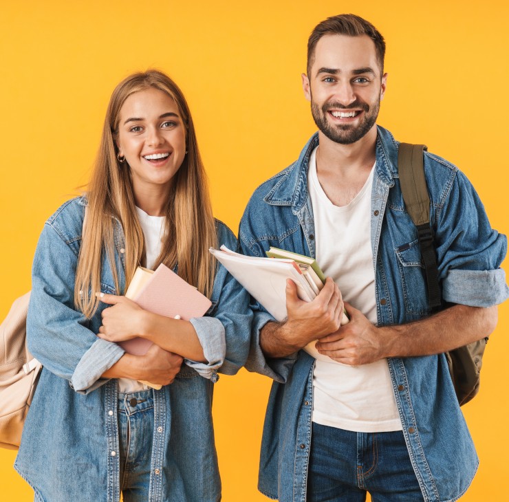 Deux étudiants avec le sourire portant leurs livres - La SMENO vous dit tout sur les critères pour obtenir de l'aide !