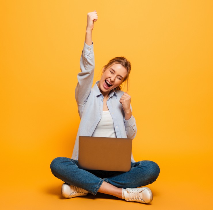 Tous sur le site de la CVEC ! Etudiante assise les jambes croisées le point levé - La SMENO vous invite à aller sur le site de la CVEC pour vous inscrire administrativement
